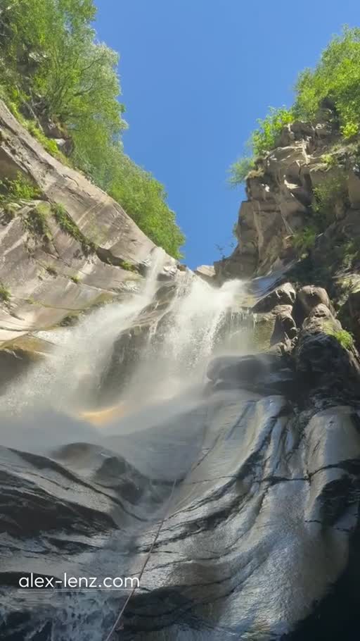 Blick vom Wasser auf einen Wasserfall zwischen Felswänden
